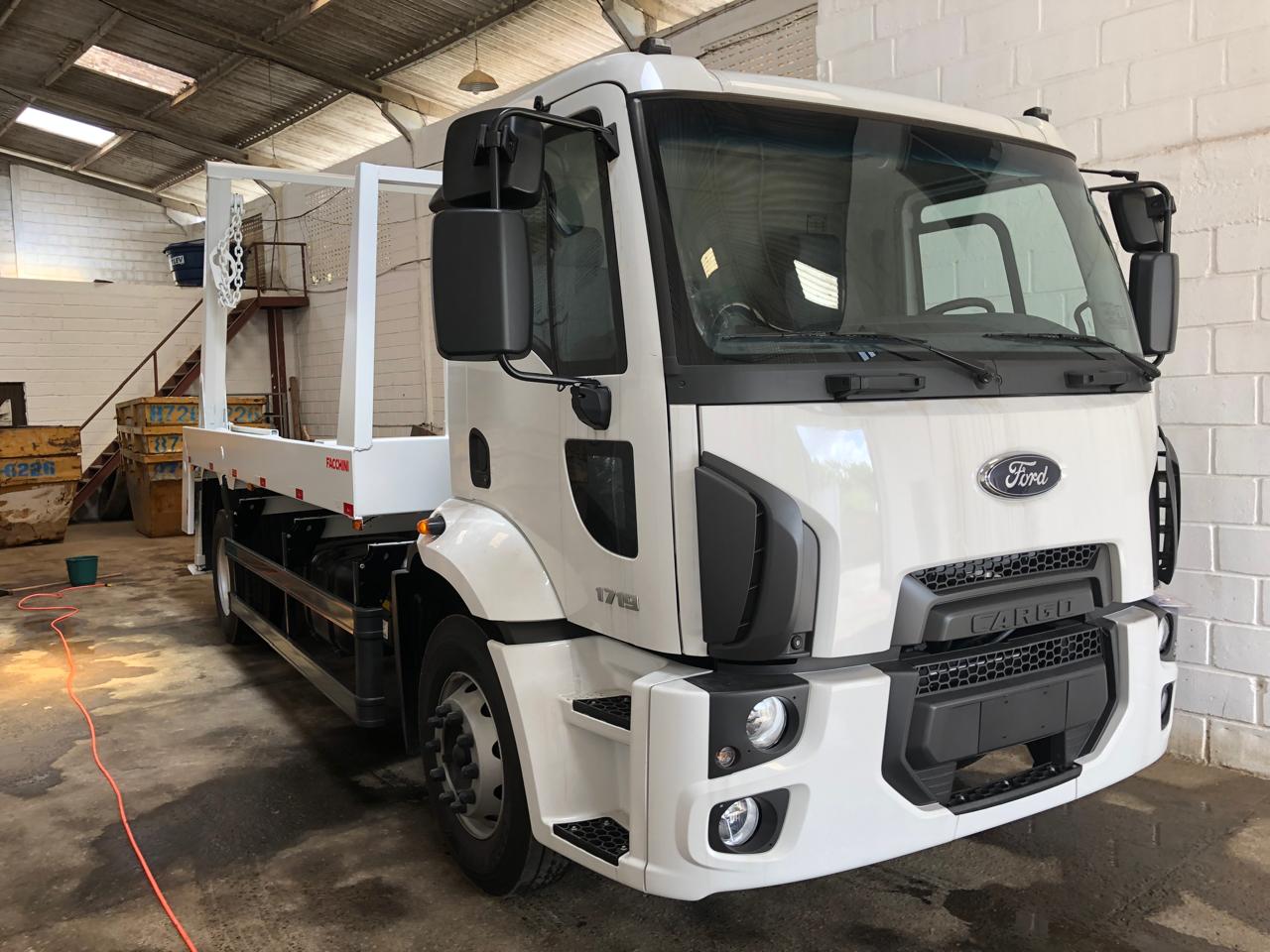 Caminhão Ford branco da frota própria da PG Entulhos