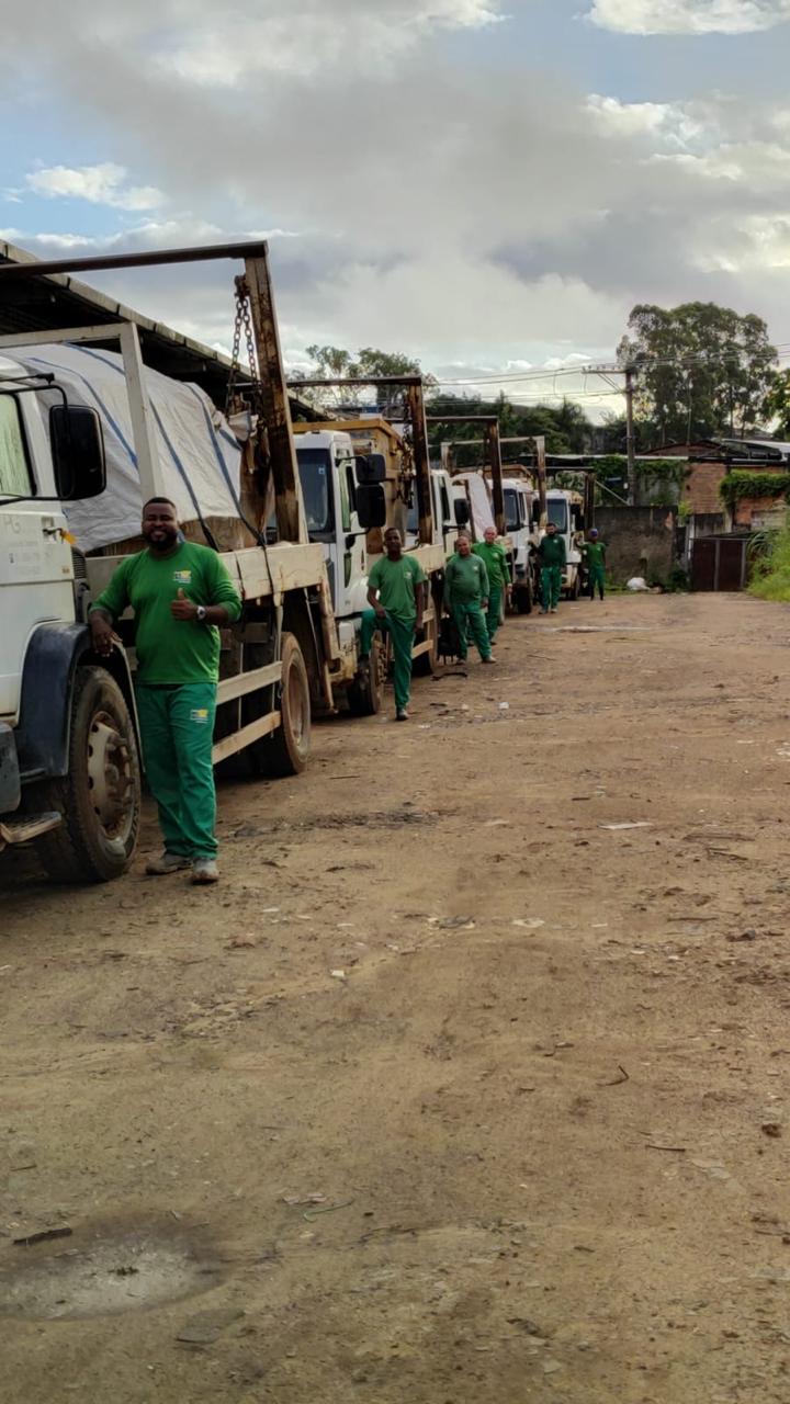 Equipe operacional da PG Entulhos junto aos caminhões alinhados